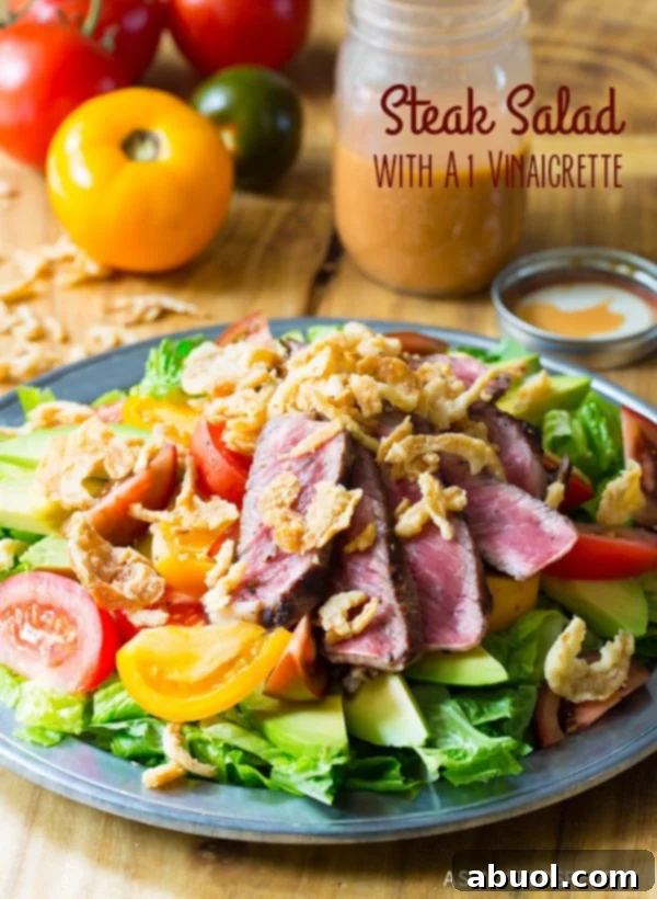 A vibrant steak salad on a blue plate, generously topped with creamy avocado slices, juicy red tomatoes, and crispy fried onions. Fresh, large tomatoes are visible in the soft background.