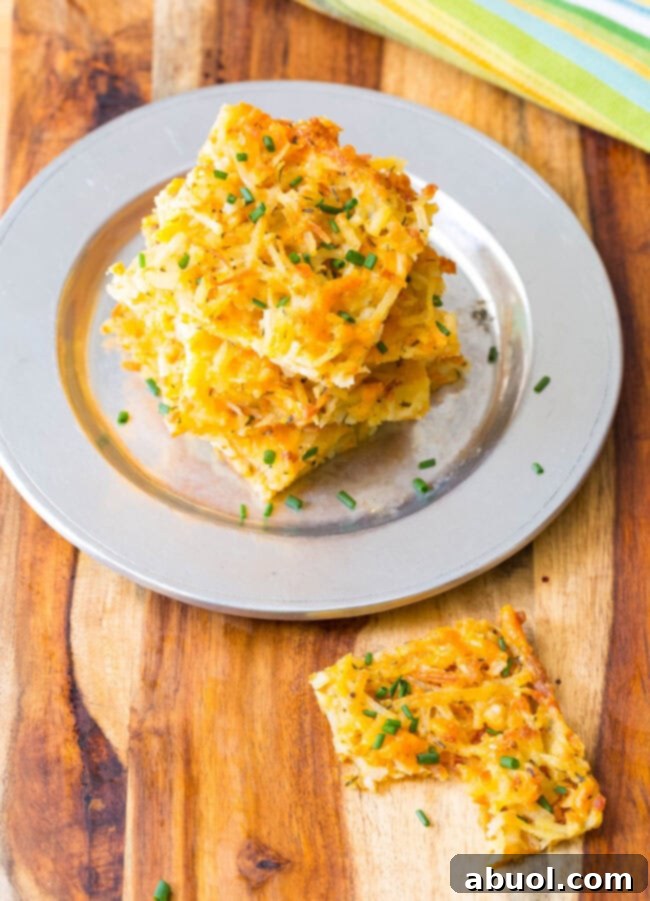 A stack of crispy baked hash browns, with one piece missing a bite, highlighting its tempting texture.