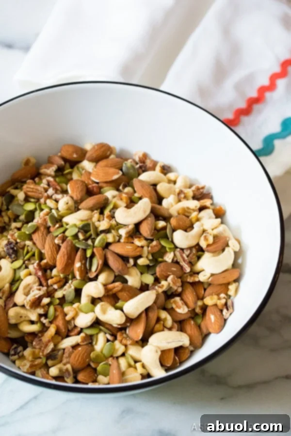 Large bowl of raw whole mixed nuts and pepitas.