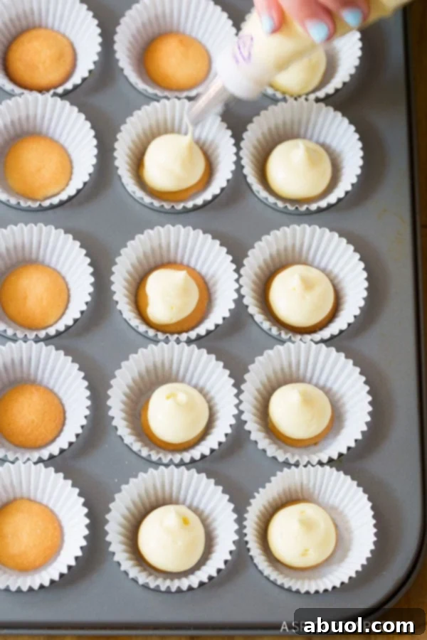 Piping vanilla pudding mixture into mini muffin liners with banana slices