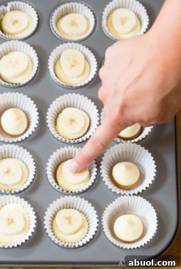 Adding more filling and tapping the muffin pan to settle the Mini Banana Cream Pies