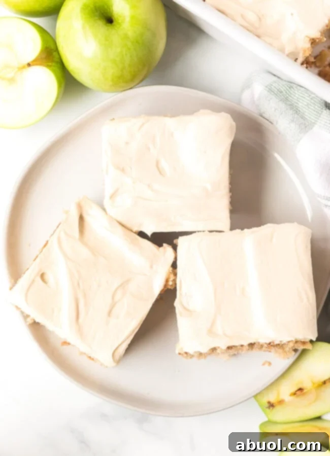 Overhead shot of three slices of apple cake with frosting on top on a plate. 