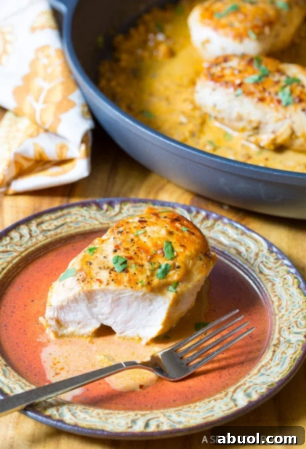 Sliced Garlic Lime Skillet Chicken A close-up shot of a Garlic Lime Chicken breast, perfectly sliced in half on a white plate, revealing its tender, juicy interior, ready to be enjoyed.