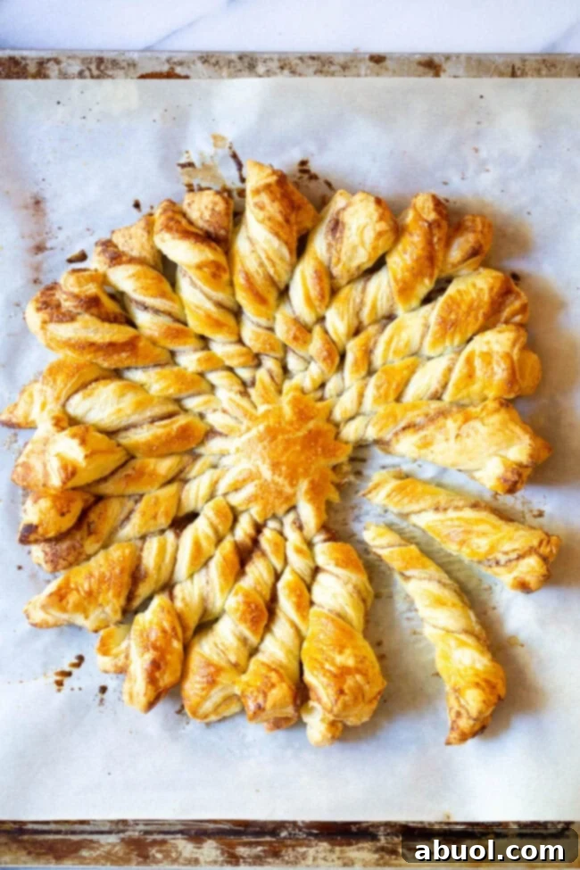 Golden brown Sunburst Pull Apart Bread with a light dusting of cinnamon sugar, ready to be pulled apart, on a white baking sheet.