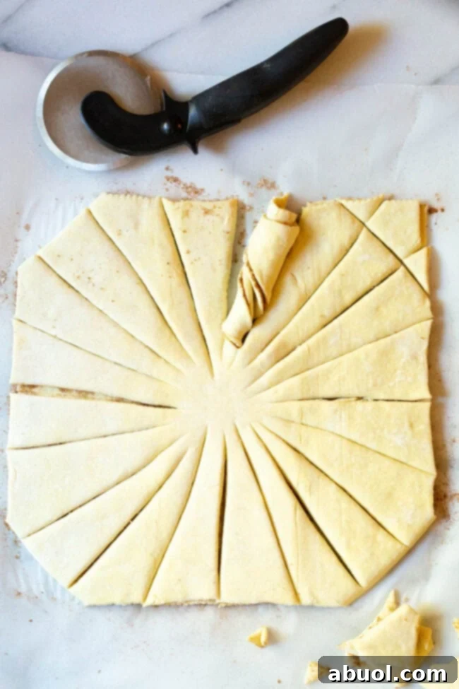 Puff pastry square cut into strips radiating from the center, ready to be twisted.