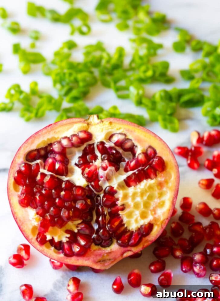 Close-up of a half pomegranate, showcasing its jewel-like arils.