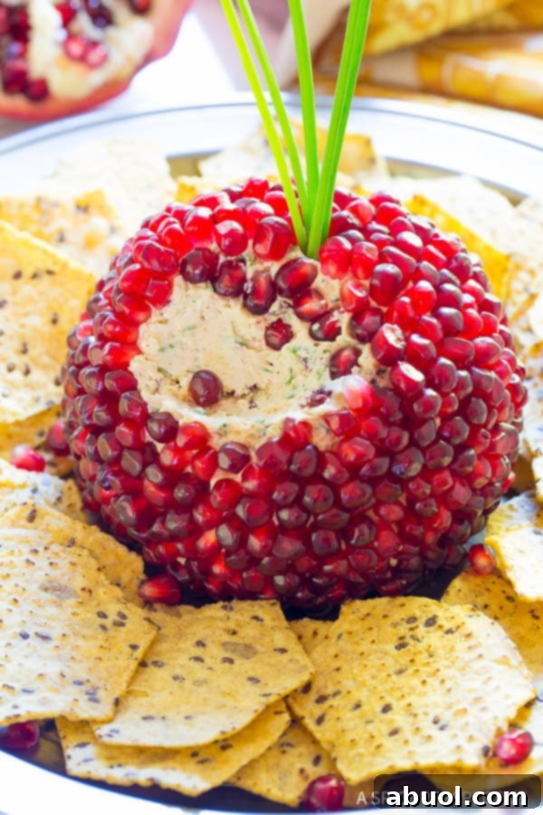 Pomegranate Jeweled Cheeseball - portion scooped out to expose soft cheese