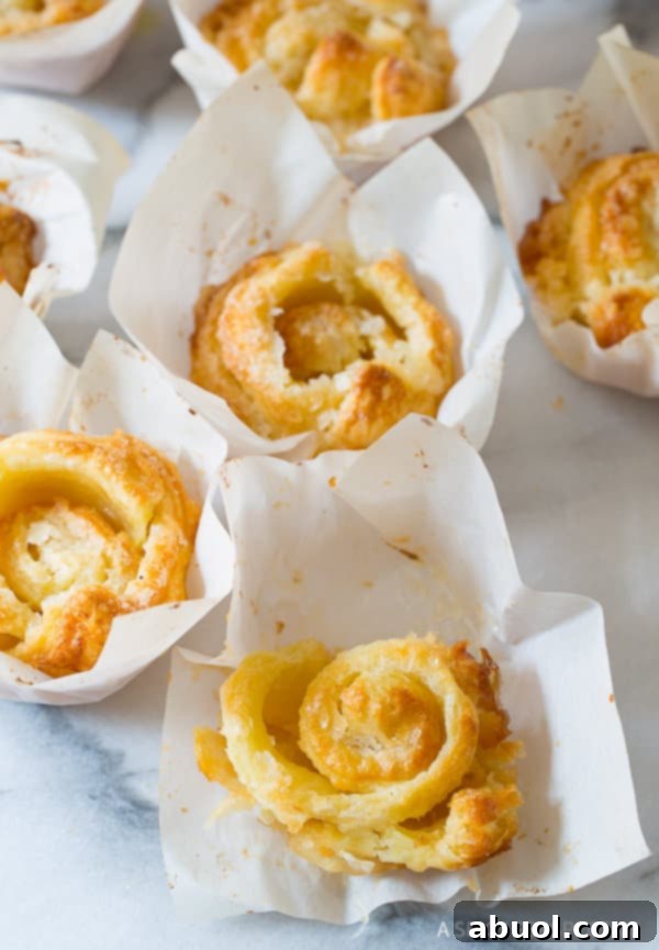 Baked Kouign Amann pastries arranged neatly in individual parchment paper squares, ready for serving.