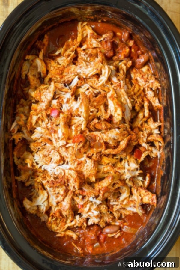 Roasted Red Pepper Crockpot Chicken Chili 8 Top down view black slow cooker filled with shredded chicken chili.
