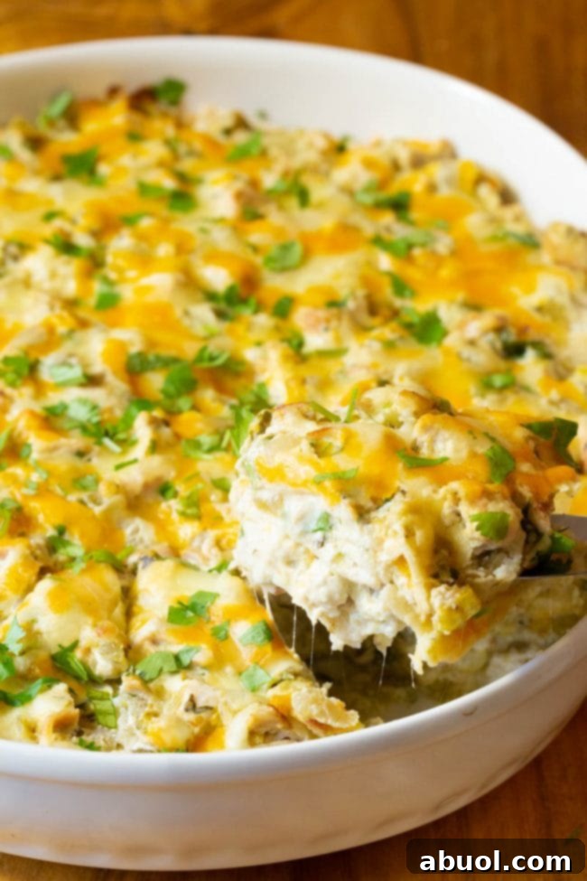Side view of the King Ranch Chicken Casserole in the dish, with a serving being lifted out, showcasing the distinct layers.