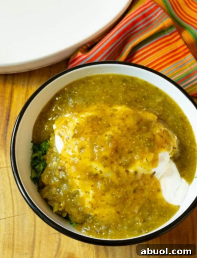 Adding sour cream and salsa verde to the chicken mixture