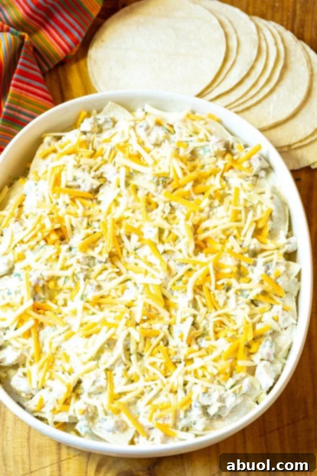 Topping the casserole with a final layer of chicken and cheese before baking