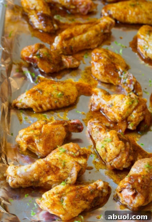 Coated Chicken Wings Chili Wings coated in chili lime sauce on a baking sheet, ready for baking.