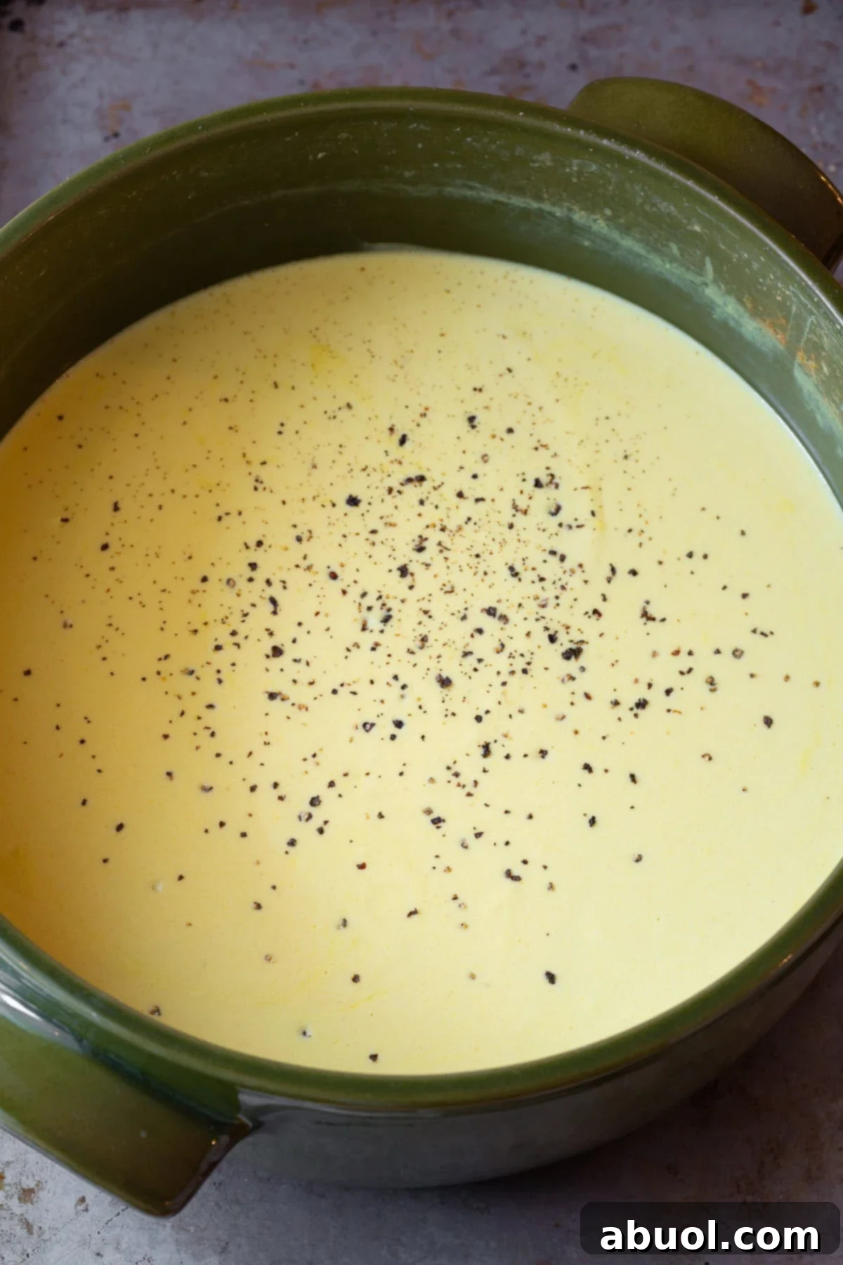 Close-up shot of Irish Beer Cheese Soup simmering gently in a large pot, showing its creamy texture and rich color as it cooks.