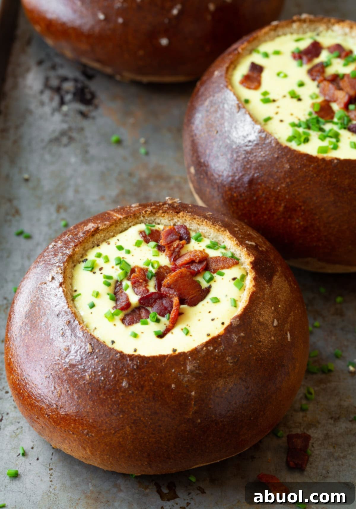 Assortment of artisan bread bowls filled with golden Irish Beer Cheese Soup, ready to be served, showcasing the rich, creamy texture.