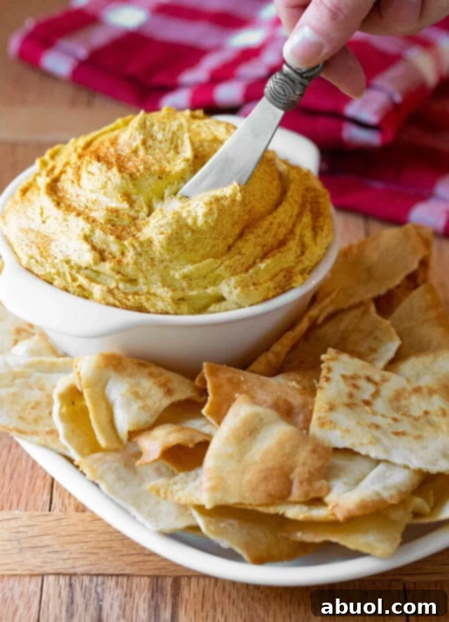 Pub cheese in a small bowl with a butter knife sticking into it. (Beer Cheese)