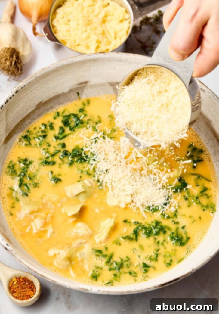 Mixing ingredients for spinach artichoke casserole in a large bowl