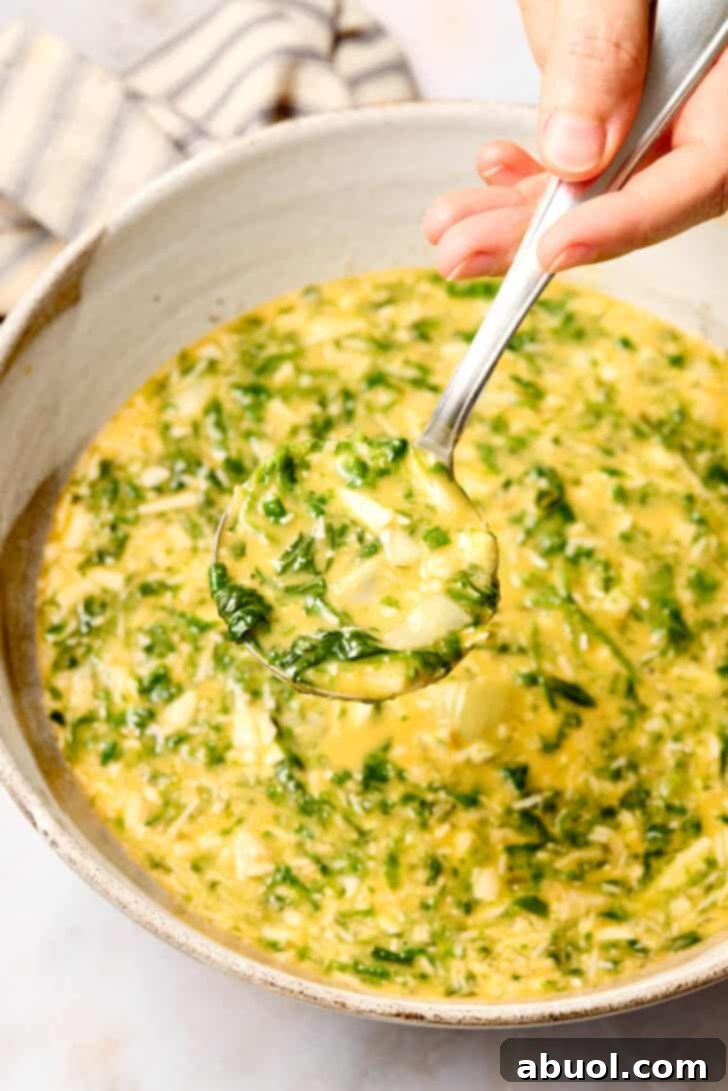 Spinach Artichoke Casserole mixture topped with ricotta, ready for the oven