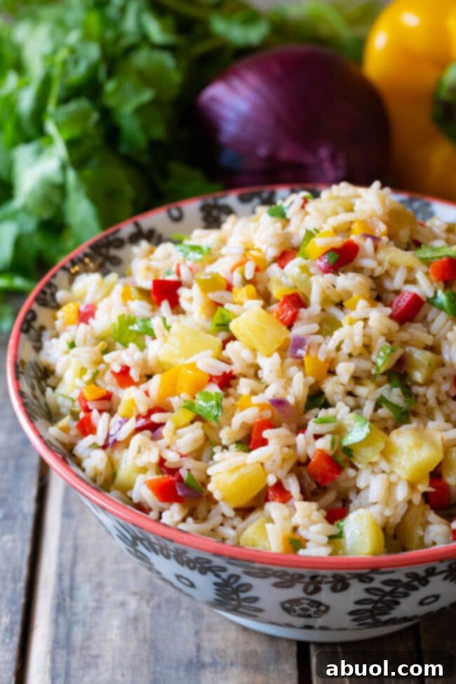 A vibrant bowl of Caribbean Confetti Rice, garnished with fresh cilantro.