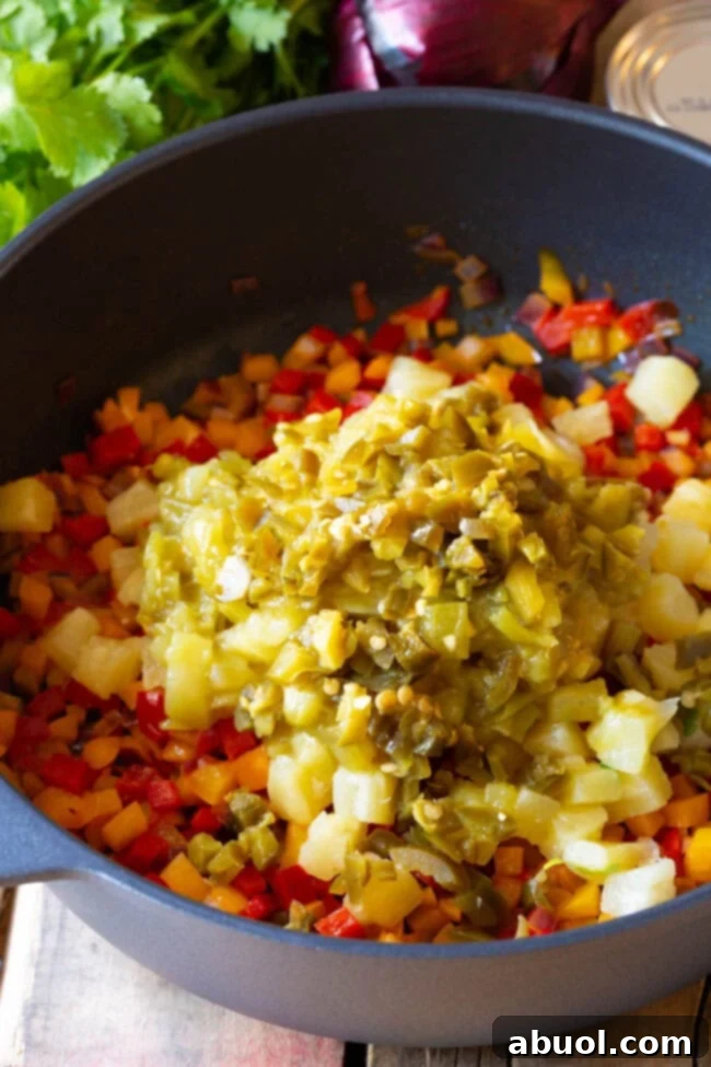 Pineapple tidbits, green chiles, and pickled jalapeños added to the sautéed vegetables.