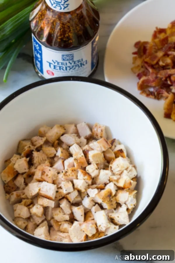A bowl filled with perfectly cooked and finely chopped grilled chicken pieces, ready for marinating.