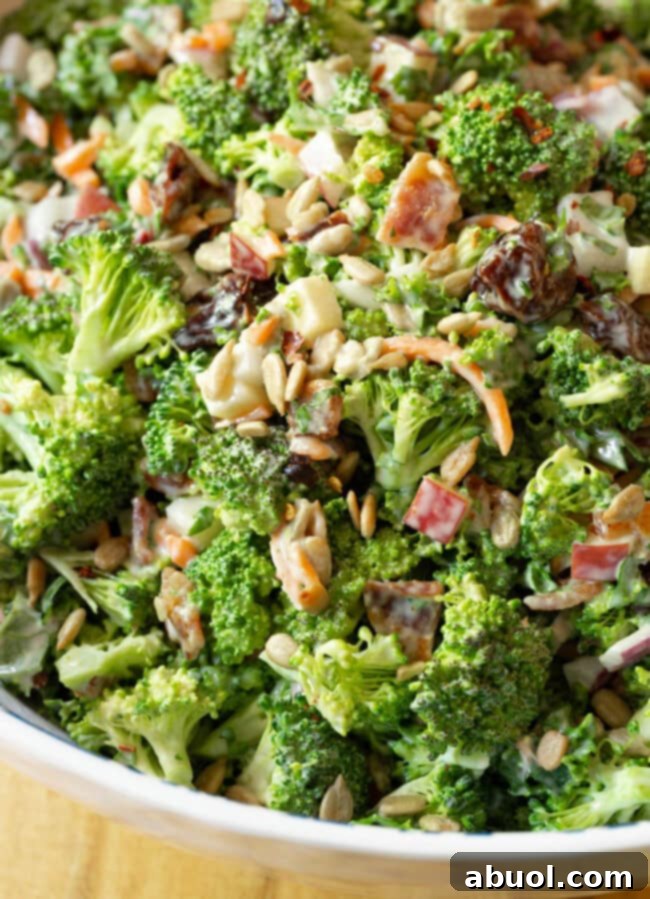 A close-up shot of fresh chunks of broccoli slaw salad with visible bacon pieces, showcasing its delicious texture.
