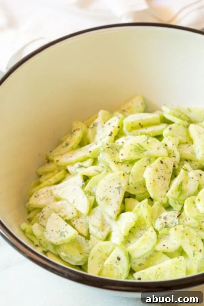 Large bowl full of this creamy sauce and cucumber salad, perfectly mixed and ready to serve.
