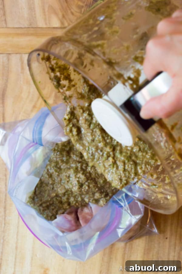 Boneless, skinless chicken thighs marinating in a flavorful jerk sauce inside a sealed zip bag.