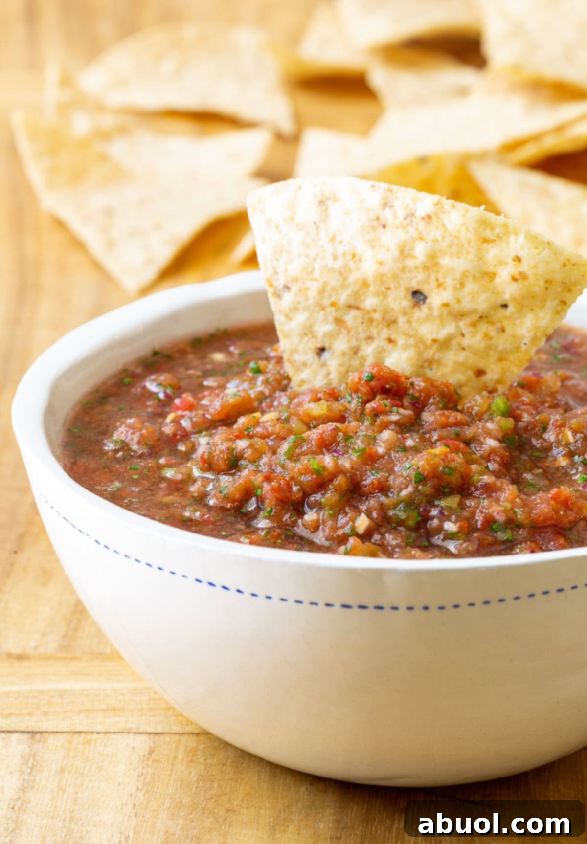 A vibrant bowl of the best homemade salsa, garnished with fresh cilantro, surrounded by crisp tortilla chips, ready for dipping.