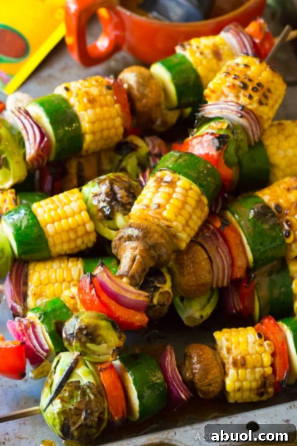 A diverse selection of grilled vegetables, including asparagus, corn, and bell peppers, on a serving platter, highlighting various grilling possibilities.