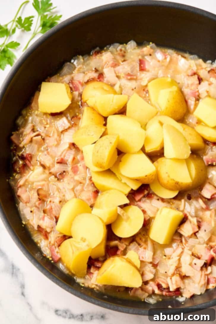 Mixing potatoes with onion and bacon