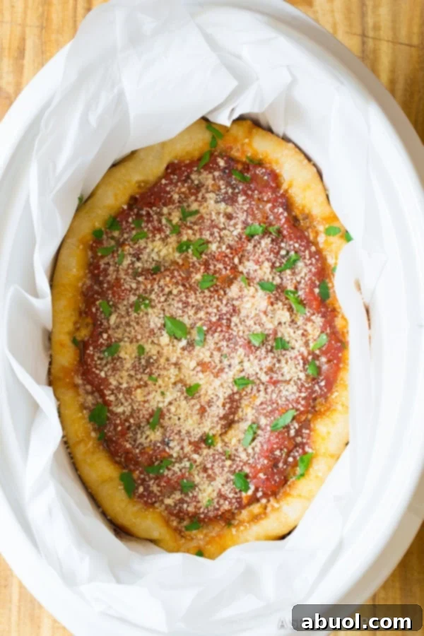 A delicious slow cooker deep dish pizza, perfectly cooked with a golden crust and bubbling cheese, ready to be sliced and served.