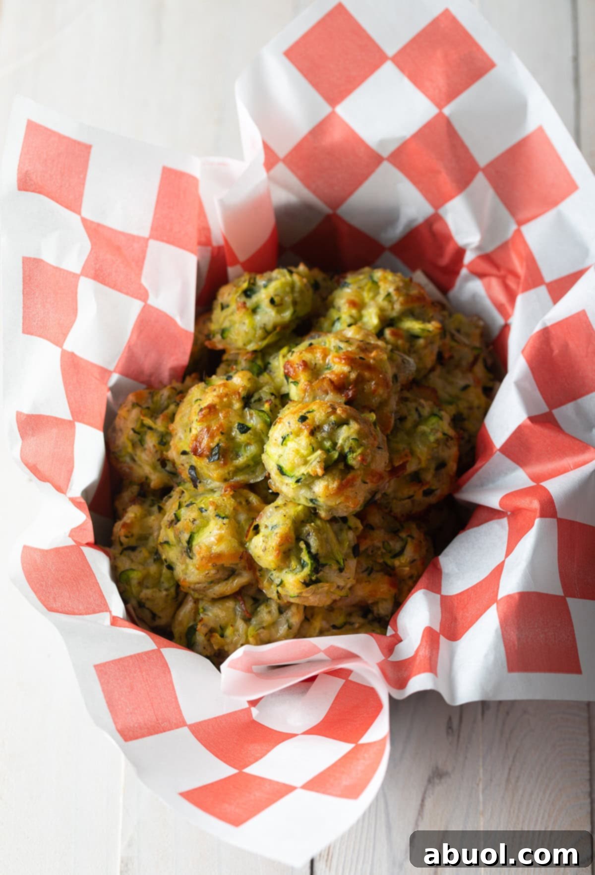 A vibrant snack basket showcasing golden, crispy baked zucchini tots, perfectly arranged for a delightful appetizer or side dish.