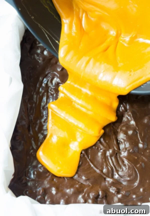 How to Make Gooey Caramel Stuffed Brownies Recipe | ASpicyPerspective.com, showing the layering process.