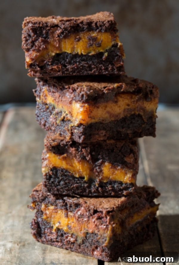 Stuffed Brownies with gooey caramel, stacked beautifully on a counter.