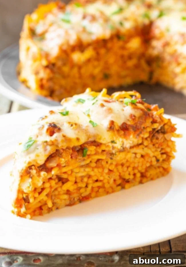 A delectable single slice of spaghetti pie, showcasing its cheesy, golden-brown top and distinct layers, ready to be enjoyed.