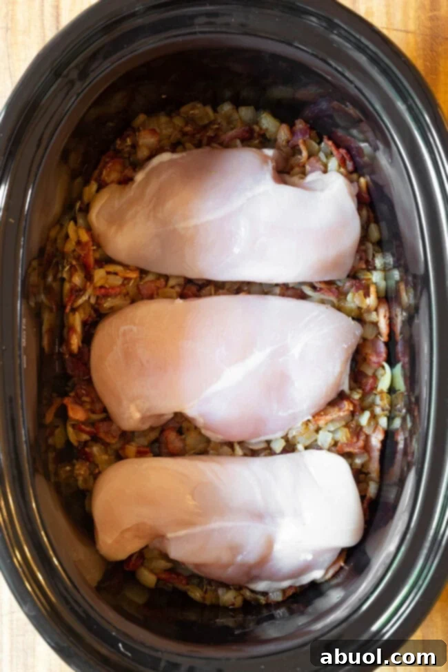 Veggies and raw chicken in the crock pot for chicken potato soup