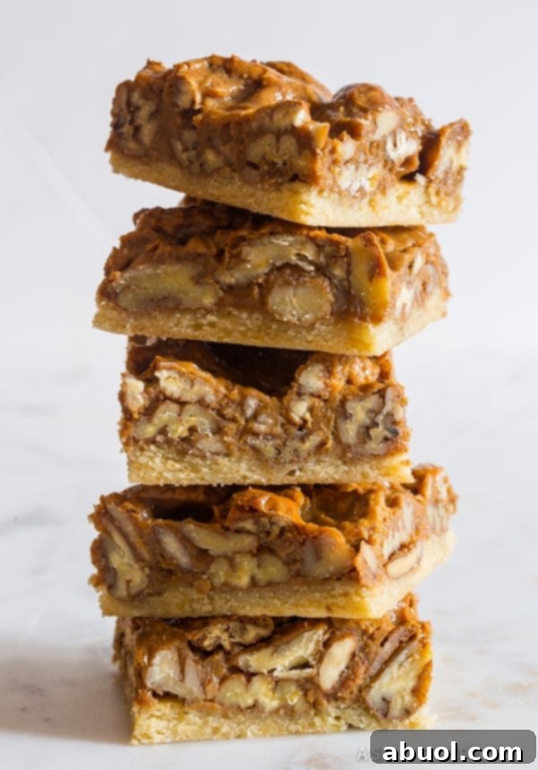 Pecan Pie bars stacked on top of each other, showcasing their inviting layers.