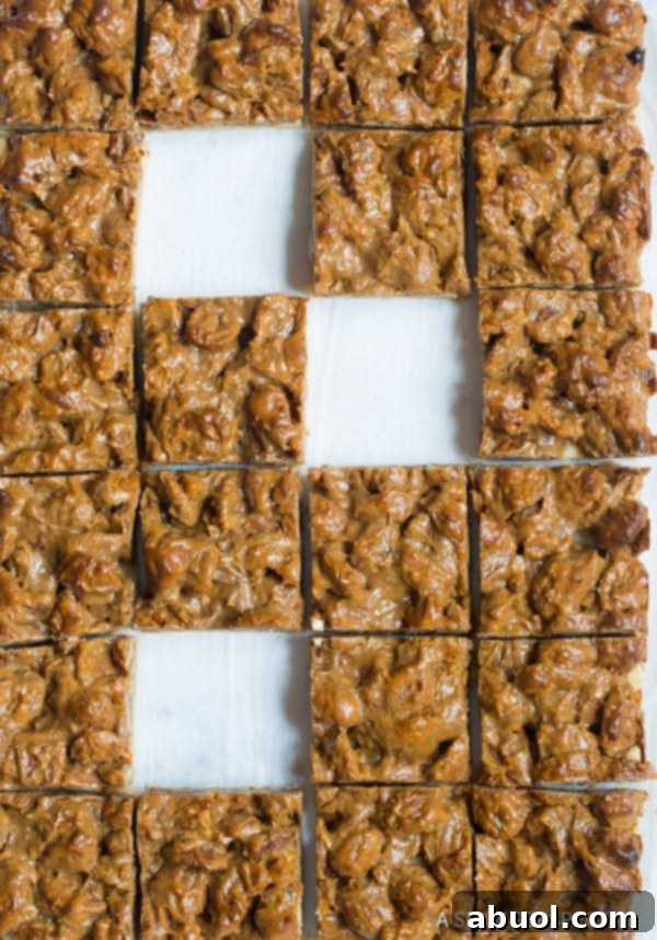 An overhead shot of a tray of pecan pie dessert bars, showcasing their golden crust and rich filling.