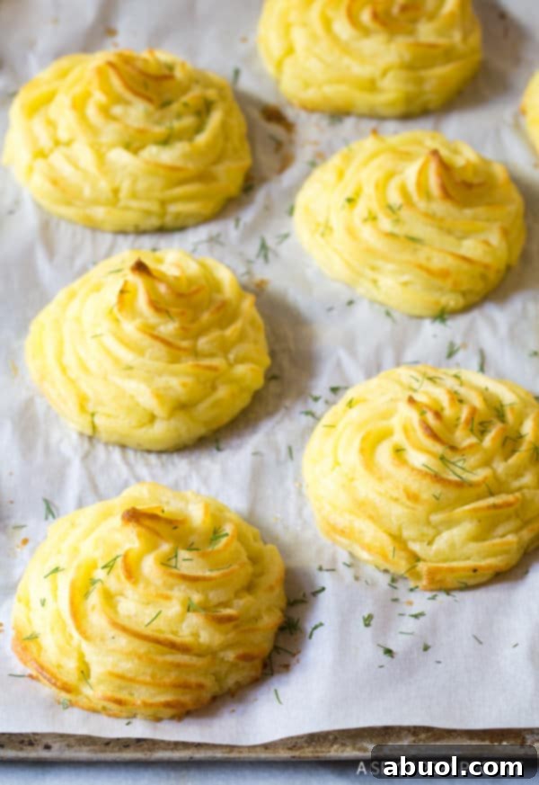 The Best Ever Duchess Potatoes Recipe on baking sheet with chopped herbs