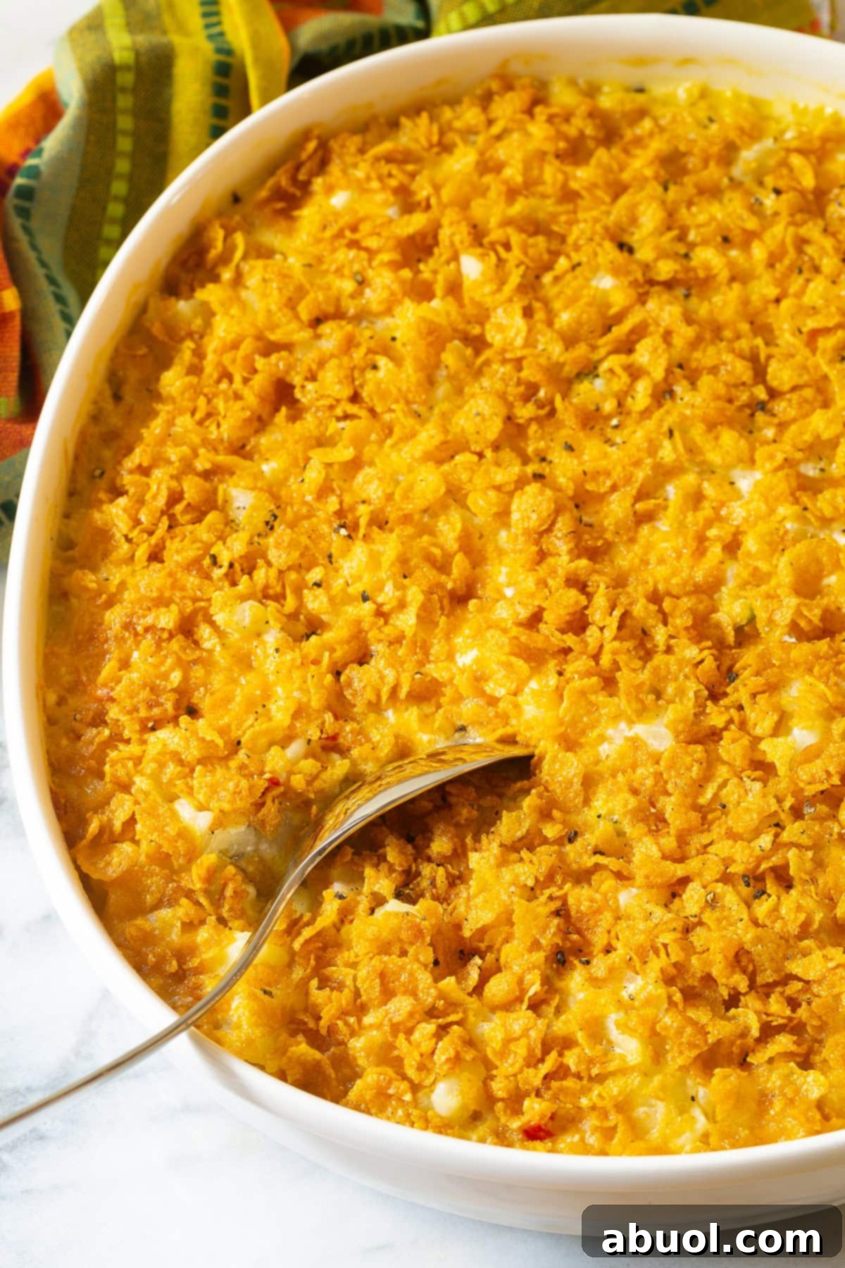 Close-up of a golden-brown Company Potatoes casserole with a crispy cornflake topping, freshly baked in a dish.