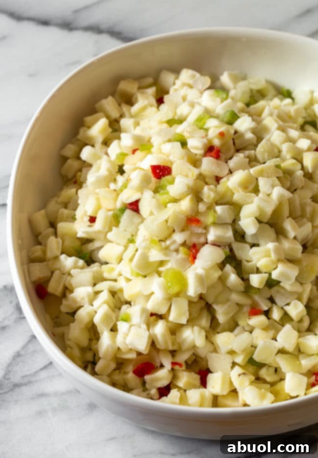 Thawed Ore-Ida hash brown potatoes in a mixing bowl, prepared for the creamy sauce.