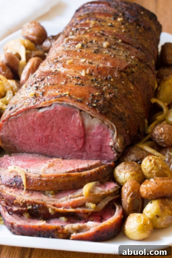 Crockpot Beef Tenderloin recipe sliced on platter with roasted potatoes