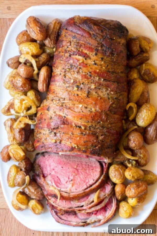 slow cooker beef tenderloin overhead shot with potatoes surrounding bacon wrapped beef tenderloin