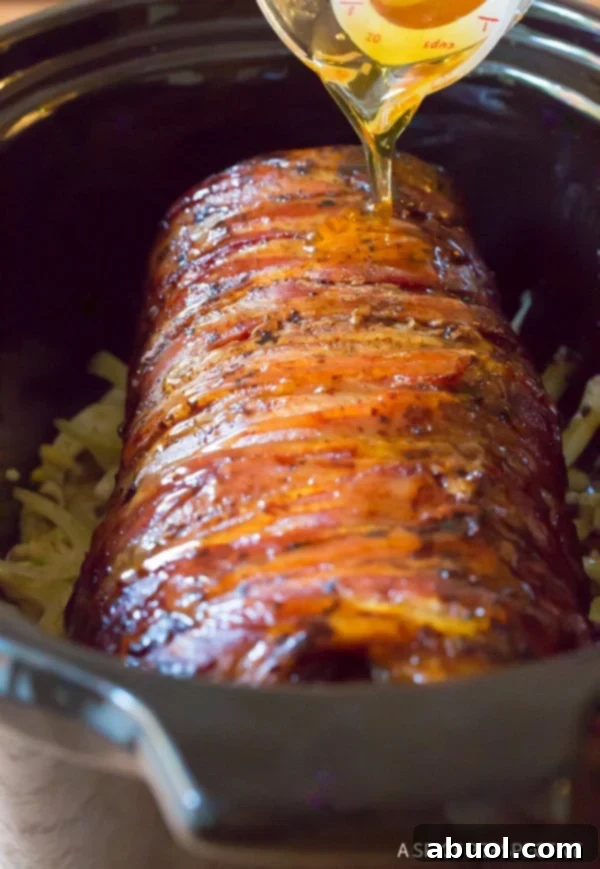 Pouring honey garlic glaze over crockpot beef tenderloin