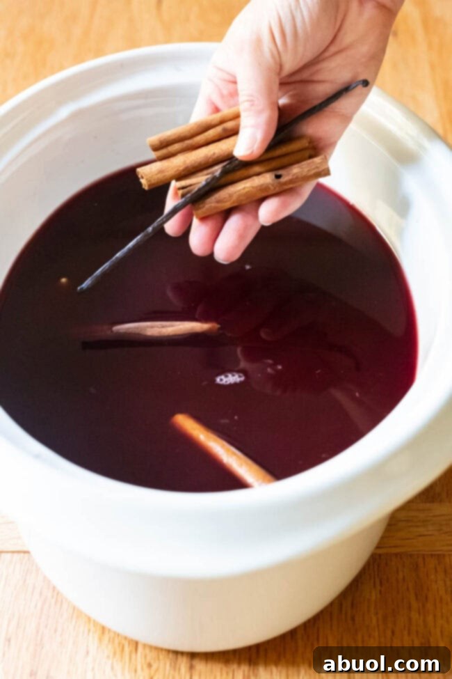 How to make homemade Mulled Wine (Wassail Recipe) on a stovetop, with ingredients like oranges, apples, and spices.