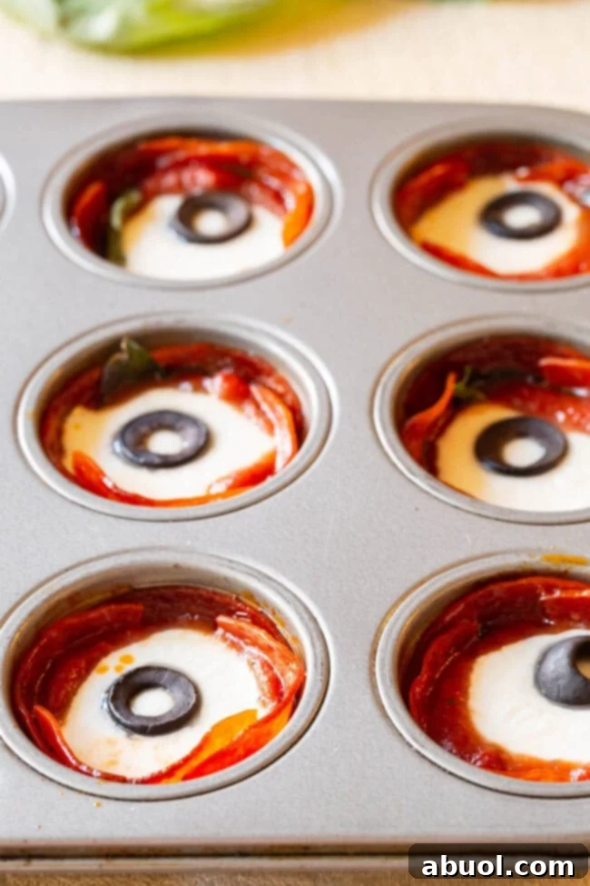 Keto Pepperoni Pizza Bites 2 Freshly baked pepperoni pizza cups cooling in a mini muffin tin, golden and ready for filling.
