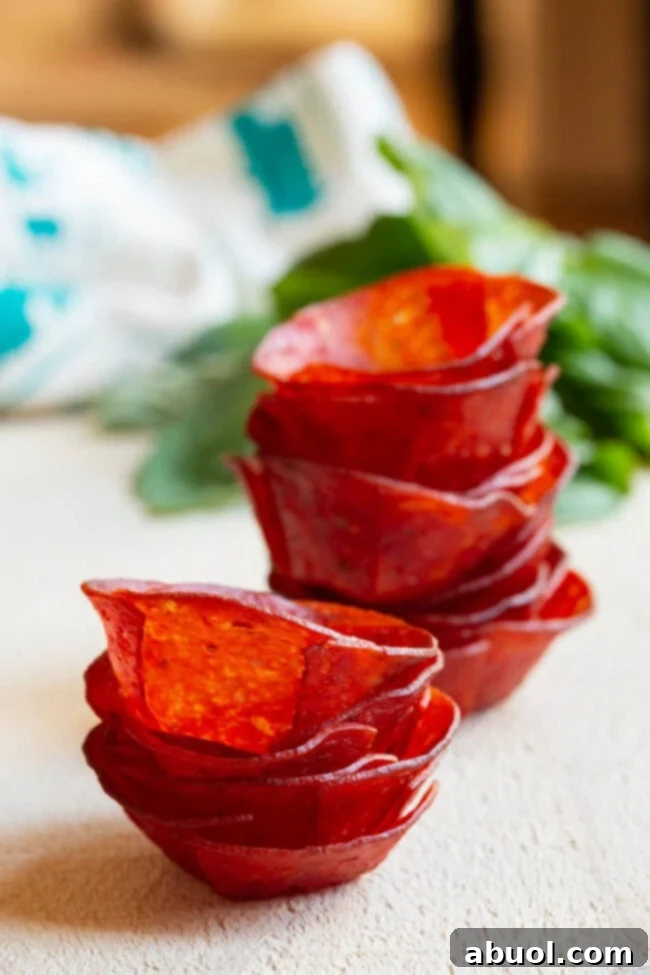 Keto Pepperoni Pizza Bites 5 Stacked crispy pepperoni cups on a plate, showing their perfect cup shape after the first bake.