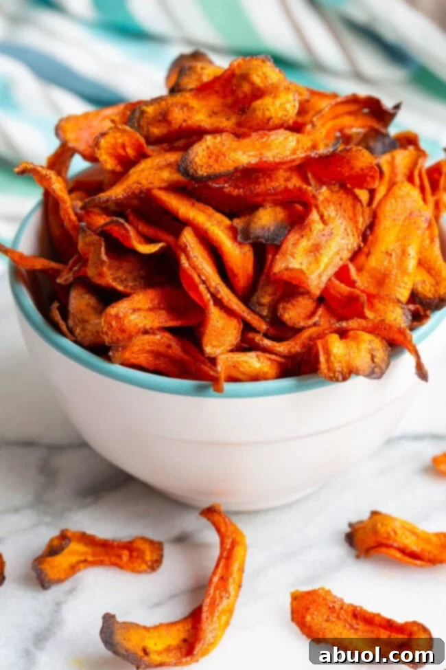 Crispy Baked Carrot Crisps 4 Perfectly baked carrot chips stacked in a stylish white bowl.