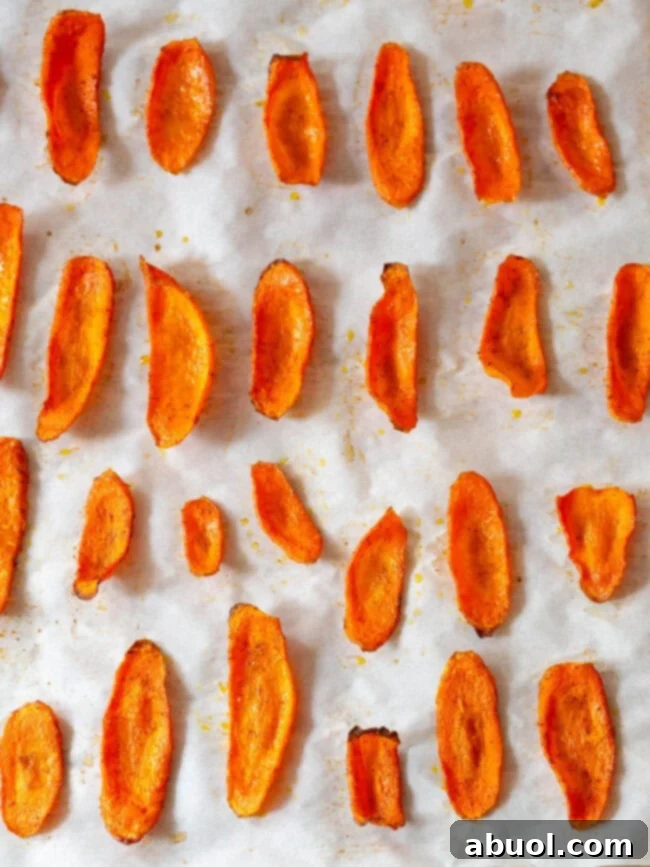 Crispy Baked Carrot Crisps 8 Golden, baked carrot slices fresh out of the oven, still on the baking sheet.
